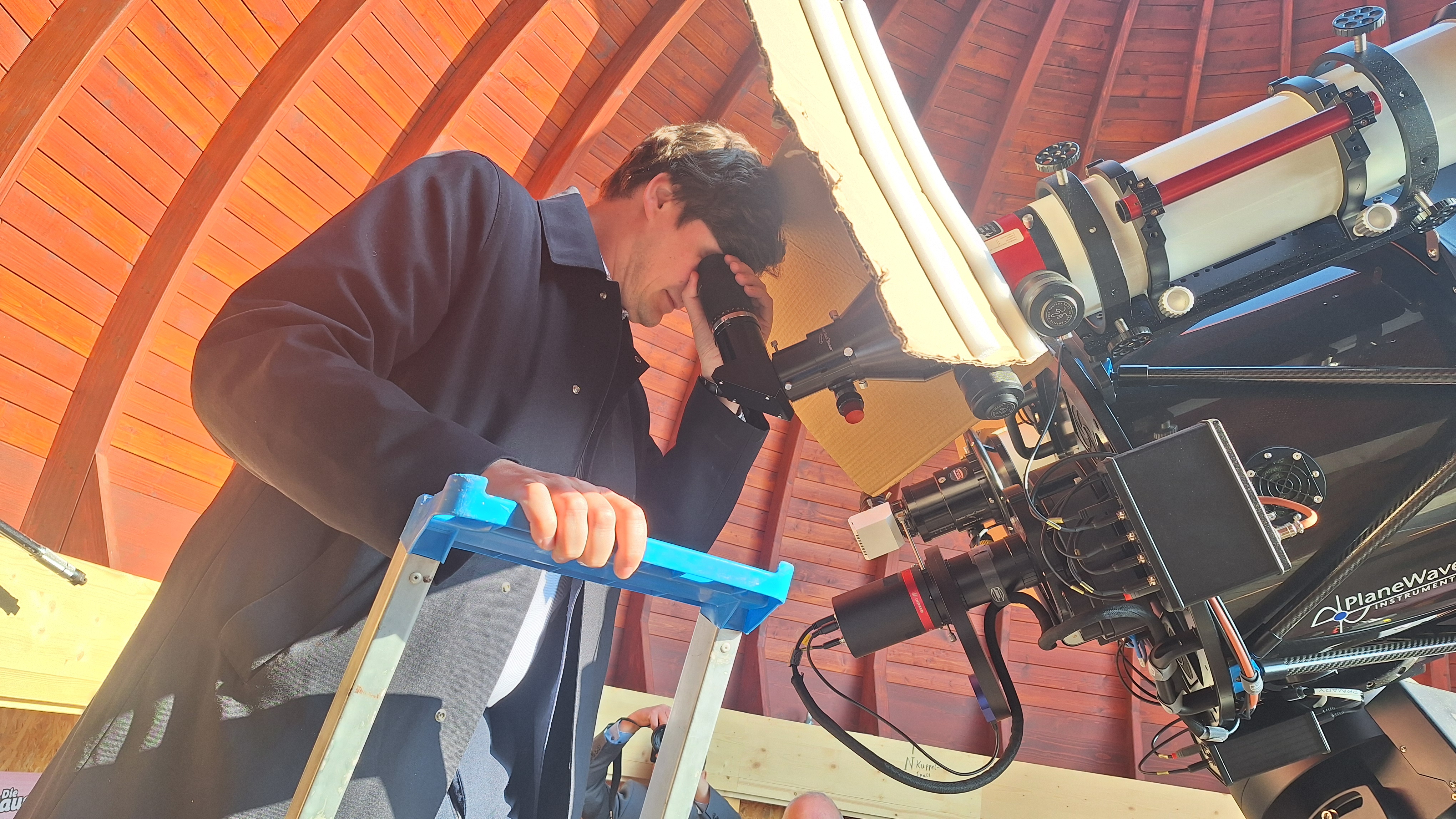 Kultusminister Clemens blickt durchs Sonnenteleskop.